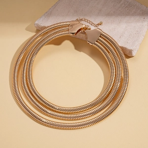 Detailed close-up of a three-layer gold snake chain necklace with lobster clasp
