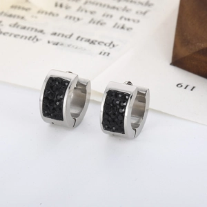 Detail of stainless steel hoop earrings with black cubic zirconia on aesthetic background