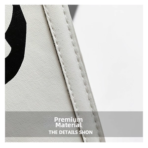 Macro detail of white lychee leather texture and precise double stitching on the bag