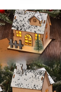 Detail view of a wooden Christmas house with LED lights and snow-covered roof design