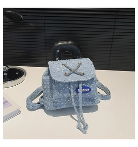 Close-up of blue sequin denim mini backpack with silver chain and Fashion label