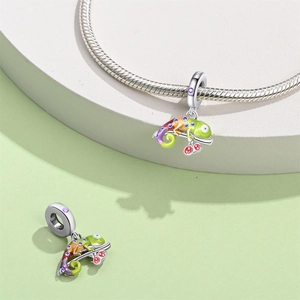 Detailed close-up of a colorful enamel chameleon charm bead on a silver snake chain bracelet