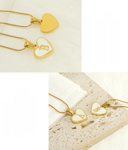 Detail of 18K gold stainless steel heart necklace with shell inlay and letter engraving