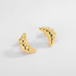 Macro detail of gold croissant stud earrings with textured s925 silver spiral design