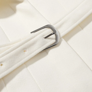 Close-up of white wool coat belt with a polished silver metal buckle detail
