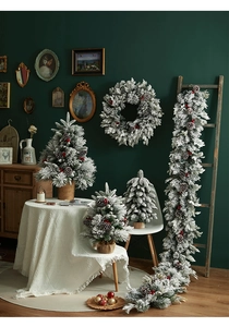Close-up of frosted Christmas tree with red berries, pine cones and matching wreaths