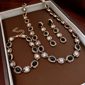 Detailed view of vintage gold jewelry set with black and white zircons in a brown velvet box