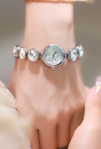 Gros plan d'une montre femme argentée élégante avec bracelet serti de cristaux