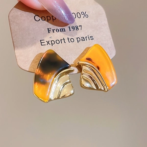 Detailed macro view of geometric amber resin and 18k gold plated geometric earrings