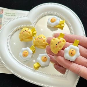 Cute resin hair clips featuring cartoon cheese and fried egg designs on a heart mirror tray