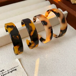 Vintage tortoiseshell resin C-shaped hoop earrings in amber and cream brown tones