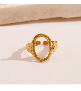 Detail view of golden adjustable ring with hollow oval design and hammered metal texture