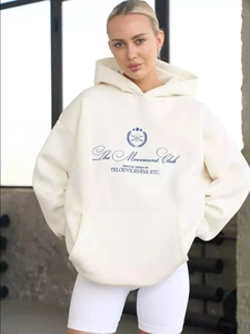 Detail shot of white oversized hoodie showing The Movement Club print and kangaroo pocket