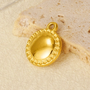 French style 18K gold plated stainless steel round pendant on a textured rock