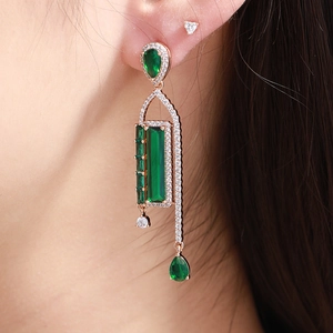 Elegant rose gold drop earrings with emerald waterdrop gems on model