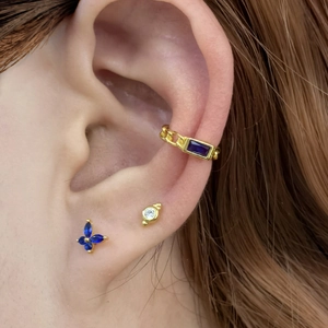 Detail of 925 silver butterfly studs and gold chain cuff with blue and purple stones