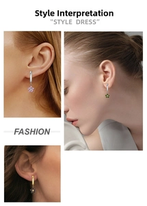 Close-up of titanium flower earrings with colorful zircon stones in gold and silver plating