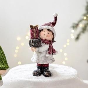 Christmas girl figurine in white sweater and red hat with gift box, winter home decor