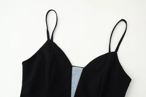 Detail of slim strap black dress featuring deep V-neckline and light blue mesh patchwork