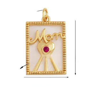Macro detail of a 17x22mm gold Mom pendant with white shell and red zircon inlay