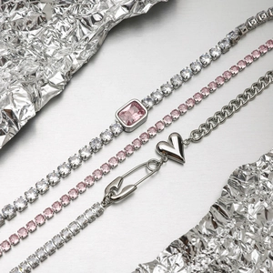 Detail of luxury tennis bracelets with pink crystals and heart pendant charms