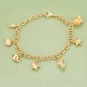 Elegant gold ocean theme charm bracelet featuring detailed shell and starfish pendants