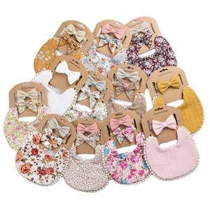 Detailed close-up of floral baby bib and headband sets arranged on a white background