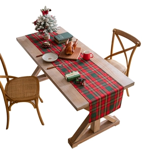 Red and green plaid Christmas table runner with gold thread on a wooden dining table