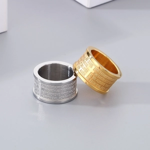 Macro shot of gold and silver stainless steel rings with Lord's Prayer engraving
