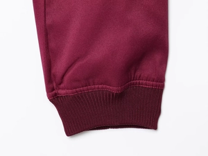 Detail of burgundy twill jacket showing elastic ribbed cuffs and premium fabric texture