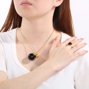 Detail of 18K gold plated snake chain necklace with black sphere pendant and matching ring