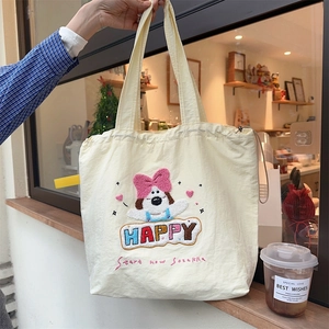 Close-up of cute dog embroidery and HAPPY lettering on beige canvas tote bag