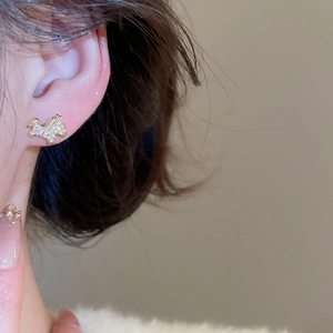 Vue macro d'une boucle d'oreille chien plaquée or ornée de zircons blancs pavés