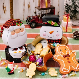 Christmas tin boxes with Santa, Snowman, and Gingerbread man shapes on a festive wood table