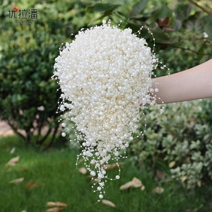 Detail of cascade bridal bouquet featuring white faux pearls and hand-woven tassels