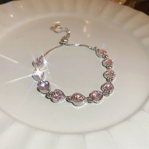 Detail of adjustable silver bracelet with eleven pink heart-shaped zircon stones