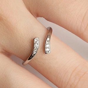 Minimalist silver-plated open ring with sparkling zircon stones worn on finger