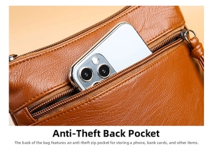 Detail view of the brown leather phone bag featuring a secure back zipper pocket