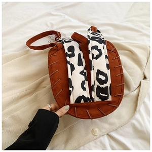 Leaf-shaped brown suede backpack featuring leopard print straps and woven leather edge detail