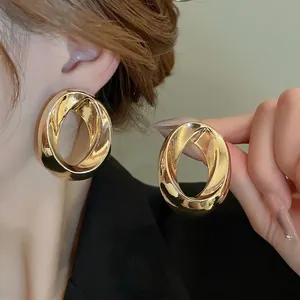 Modern minimalist chunky twisted gold hoop earrings with mirror polished finish