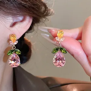 Elegant gold earrings set with pink pear-shaped zircon and green marquise leaves