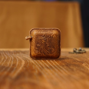 Macro view of embossed floral pattern on vintage brown genuine leather mini tape measure
