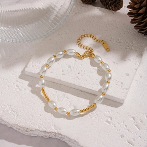 Détail d'un bracelet en perles d'acier inoxydable plaqué or 18 carats sur une pierre