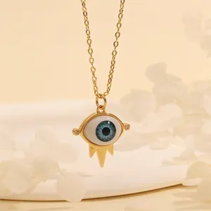 Macro detail of Evil Eye pendant necklace with 18K gold plating and blue resin eye