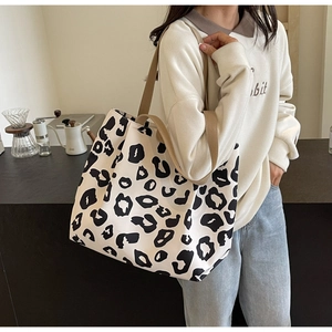 Sac fourre-tout en toile à motif léopard porté à l'épaule par un mannequin en ville