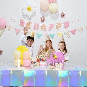 Close-up of holographic laser tablecloth with festive party decorations and balloons