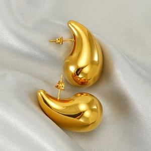 Polished 18K gold teardrop earrings in high gloss finish on grey silk fabric
