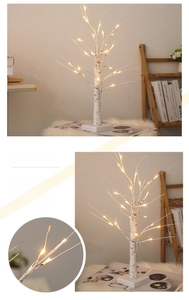 Detail of warm LED lights on artificial birch tree branches for festive home decor