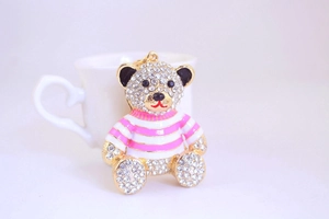 Close-up of golden alloy bear keychain with full crystal rhinestones and striped enamel shirt