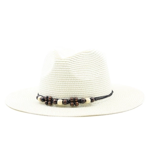 Detailed shot of the bohemian dark brown and beige wood bead trim on the cream panama hat